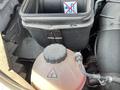 Engine compartment of a 2022 Mercedes-Benz Sprinter showing a reservoir tank with a black cap and a plastic container indicating no drinking water