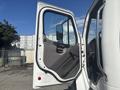 A 2022 Freightliner M2 106 truck door is open showcasing the interior door design and control panel