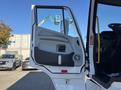 A white 2022 Lion Lion6 truck with an open driver's door displaying a large control panel and modern design elements
