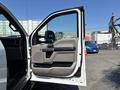 A 2017 Ford F-550 truck with an open driver's side door showing a gray interior panel and handle