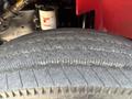 Close-up of a worn tire from a 1999 Freightliner FL80 showing visible cracks and uneven tread patterns