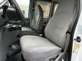 A gray fabric driver's seat in a 2006 Ford Econoline with a simple dashboard and gray interior detailing