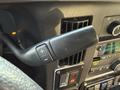 Close-up of the gear shift lever of a 2019 Chevrolet Express with buttons for gear selection and controls on the dashboard
