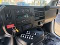Interior view of a 2020 Chevrolet Express showing the dashboard with a radio, climate controls, and a control panel with various buttons and a key in the ignition