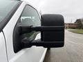 Close-up of a side mirror on a white 2008 Ford F-250 SD covered in raindrops