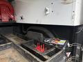 A 2016 RAM 1500 truck bed featuring a wooden storage area with several red plastic dividers and a tool compartment displaying various tools and equipment