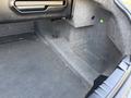 A black 2004 BMW 6-Series with a spacious empty trunk featuring gray carpeting and minimal storage compartments