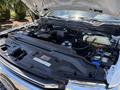 The image shows the open hood of a 2020 Ford F-350 SD revealing its engine compartment with various components like the battery and coolant reservoir visible inside the engine bay