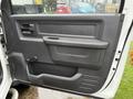 The interior door panel of a 2012 Dodge Ram 5500 featuring a black plastic handle a storage compartment and a textured surface