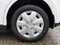 Close-up of a silver alloy wheel with five spokes mounted on a tire labeled Kumho Sol. The wheel is part of a white 2012 Nissan Versa
