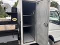 A metallic storage compartment with an open door revealing two shelves inside