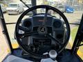 Steering wheel and dashboard of a 2013 John Deere 710K tractor showing controls and a logo