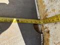 A measuring tape is laid out across a surface, showing a measurement of 65 inches with markings visible along its length
