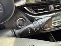 A close-up view of the steering column controls in a 2021 Toyota C-HR featuring turn signal and windshield wiper controls with an engine start stop button nearby