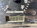 Close-up of a John Deere 3320 300X instrument panel showing the hour meter reading 2034.6 hours and various dials for gauges