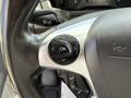 A close-up of the steering wheel of a 2016 Ford Transit featuring a control button with an "OK" symbol and directional arrows