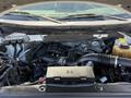 The image shows the engine compartment of a 2014 Ford F-150 with various engine components including the air intake manifold and wiring harnesses visible