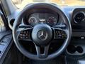 Steering wheel of a 2023 Mercedes-Benz Sprinter 2500 featuring the emblem and various controls within the driver's cockpit