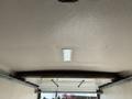 Interior view of a 2023 Ford E-450 showcasing the ceiling with a light fixture and a smooth surface