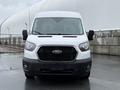 A white 2022 Ford Transit van with a black grille and headlights visible in the foreground