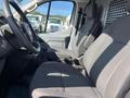 Interior of a 2017 Ford Transit showcasing two gray fabric seats with striped patterns and a steering wheel in the foreground