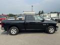 A black 2015 RAM 1500 pickup truck with a crew cab and standard bed displayed from the side with a visible logo on the door