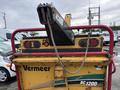 A yellow Vermeer Corporation BC1200XL chipper with a red frame featuring lights and a feeding chute visible at the top