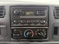 Interior dashboard controls of a 2004 Ford F-750 featuring radio and climate control buttons