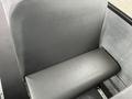 A gray bus seat from a 2007 Freightliner B2 with a smooth surface and a low backrest designed for passenger seating
