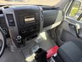 Interior of a 2016 Mercedes-Benz Sprinter featuring a dashboard with a touchscreen display and controls alongside a driver's seat and gear shift