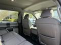 Interior of a 2021 Ford F-250 SD showing front and rear seats in gray fabric with a center console visible in between the front seats