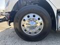 Close-up of a 2014 Freightliner M2 106 wheel featuring a shiny chrome hubcap and thick black tire with the brand name Double Coin visible