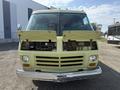A 1976 GMC Motorhome with its hood open revealing the engine compartment and mechanical components inside