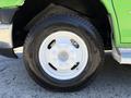 Close-up of a white wheel on a green 2013 Chevrolet Express van showcasing the tire tread and wheel design