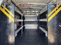 Interior of a 2019 GMC Savana cargo van featuring metal shelving units secured to the walls with a black and yellow striping pattern