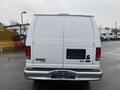 A white 2011 Ford Econoline E250 van viewed from the rear with a blank license plate and a simple tailgate design