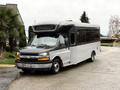 A 2020 Chevrolet Express bus in a two-tone black and silver color with large windows and a prominent front hood design