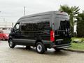 A black 2022 Mercedes-Benz Sprinter van with a high roof and large cargo space is parked, showing its rear view and distinct design features