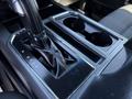 The interior console of a 2018 Ford F-150 featuring a gear shifter and dual cup holders
