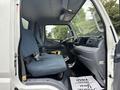 A 2015 Mitsubishi Fuso FE160 interior showing two blue seats and the dashboard with various controls and displays