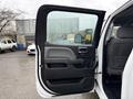 A 2015 GMC Sierra 1500 with its driver's side door open showing the interior door panel and handle