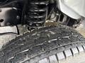 A close-up of a tire with a detailed tread pattern and visible suspension components of a 2024 Ford E-450