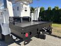 A 2013 International 7500 truck with a sturdy flatbed and a hydraulic lift mechanism at the rear designed for utility work