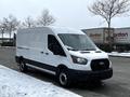 A 2021 Ford Transit van in white color with a sleek design and a high roof parked on a snowy street