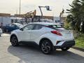 A 2021 Toyota C-HR in white parked with a blank rear license plate and distinctive styling featuring sleek lines and a compact design