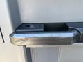 Close-up of a 2017 Ford F-550 door handle showing a rectangular shape with a textured grip and a small window control panel