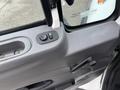 The interior door panel of a 2013 International Workstar 7500 featuring a control for the window and a handle