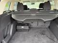The interior of a 2015 Ford Escape showing the rear trunk space with a black storage box and a cover over the cargo area