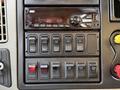 Interior controls of a 2016 International 7400 featuring a radio display and multiple switches for various functions
