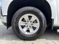 A close-up view of a 2019 Chevrolet Silverado 1500 wheel featuring a silver alloy rim and a rugged Bridgestone Dueler tire